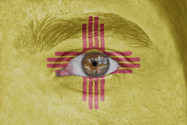 Menselijk gezicht en ogen geschilderd met ons vlag van New Mexico — Stockfoto