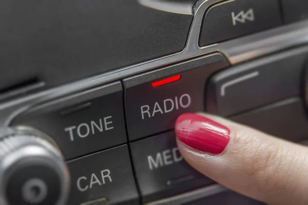 按汽车收音机立体声面板和现代仪表板电极的女孩 — 图库照片