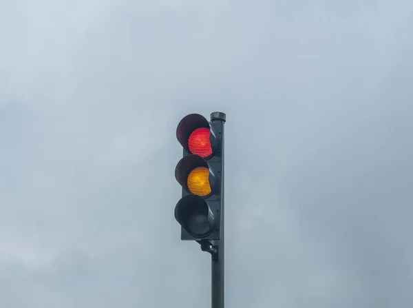 Sinal de semáforo vermelho e amarelo com céu dramático nublado — Fotografia de Stock