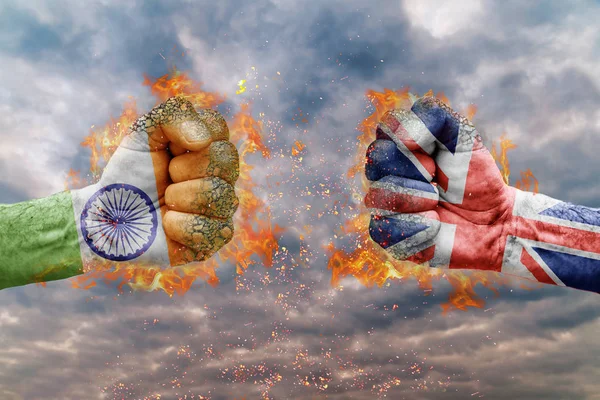 Два кулак з прапор Індії та Великої Британії стикаються один на одного готові до боротьби — стокове фото