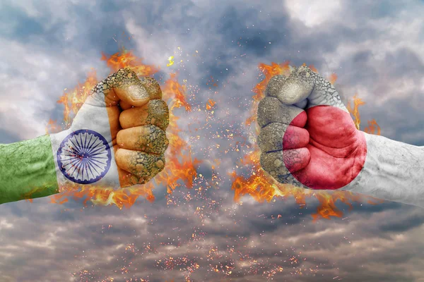 Два кулак з прапор Індії та Японії стикаються один на одного готові до боротьби — стокове фото