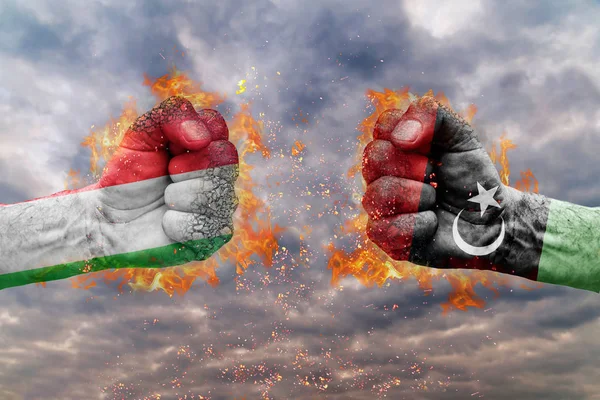 Два кулак з прапор Італії та Лівії стикаються один на одного готові до боротьби — стокове фото