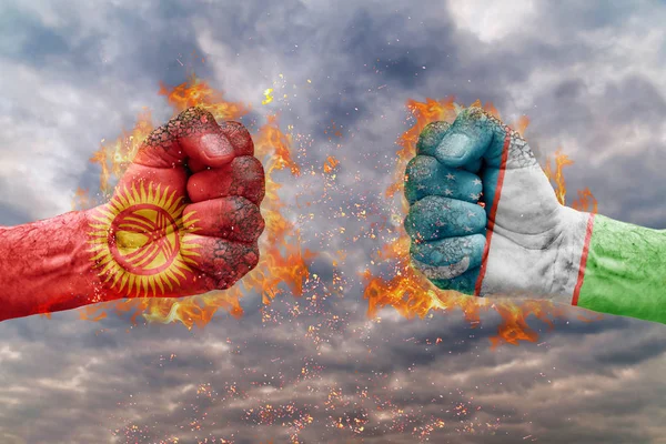 Kırgızistan bayrağı ile iki yumruk ve Özbekistan birbirlerine karşı karşıya mücadele için hazır