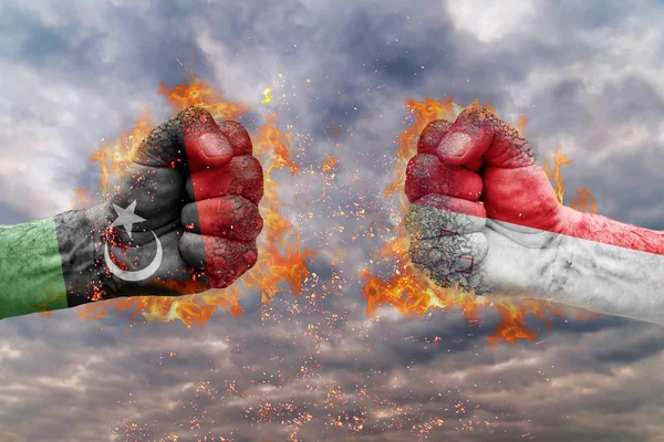 Два кулак з Прапор Лівії і Мальти стикаються один на одного готові до боротьби — стокове фото