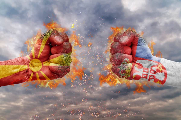 Два кулак з прапором Македонії і Сербія стикаються один на одного готові до боротьби — стокове фото