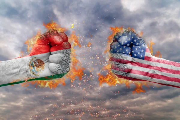 Two fist with the flag of Mexico and USA faced at each other ready for fight