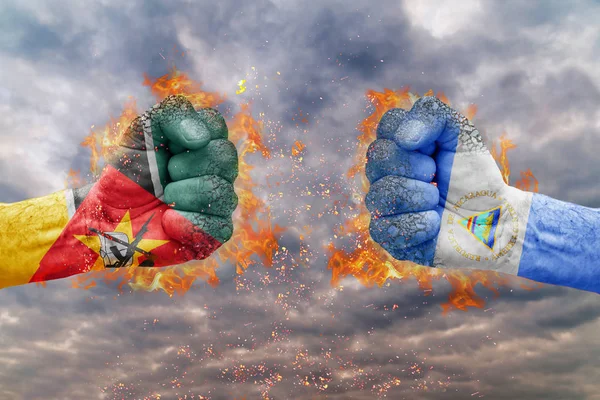 Two fist with the flag of Mozambique and Nicaragua faced at each other ready for fight — Stock Photo, Image