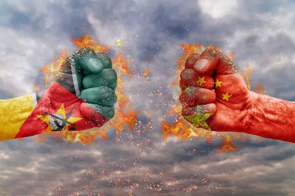 Два кулак з прапор Мозамбіку та Китай стикаються один на одного готові до боротьби — стокове фото