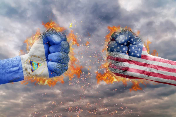 Two fist with the flag of Nicaragua and USA faced at each other ready for fight — Stock Photo, Image