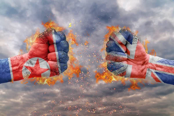 Два кулак з прапором Північної Кореї та Великої Британії стикаються один на одного готові до боротьби — стокове фото
