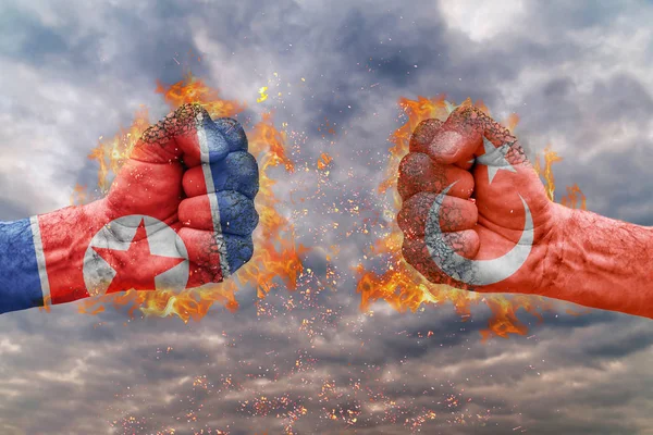 Dua kepalan tangan dengan bendera Korea Utara dan Turki saling berhadapan siap untuk bertempur — Stok Foto