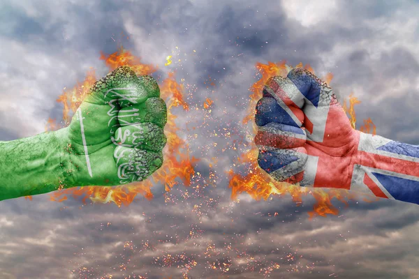 Dwie pięści z flaga Arabii Saudyjskiej i Wielkiej Brytanii do czynienia na siebie gotowy do walki — Zdjęcie stockowe