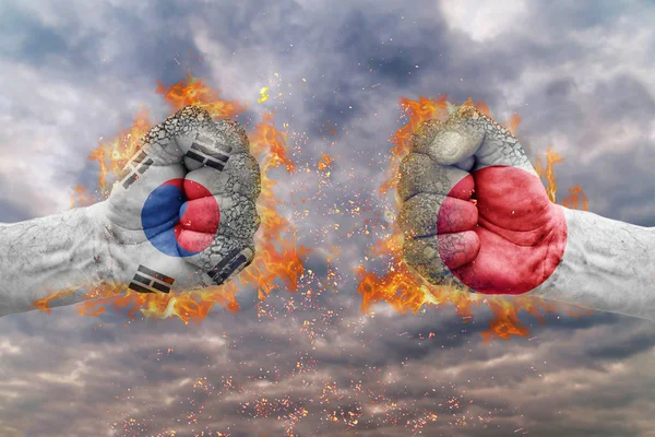 Güney Kore bayrağı ile iki yumruk ve Japonya birbirlerine karşı karşıya mücadele için hazır