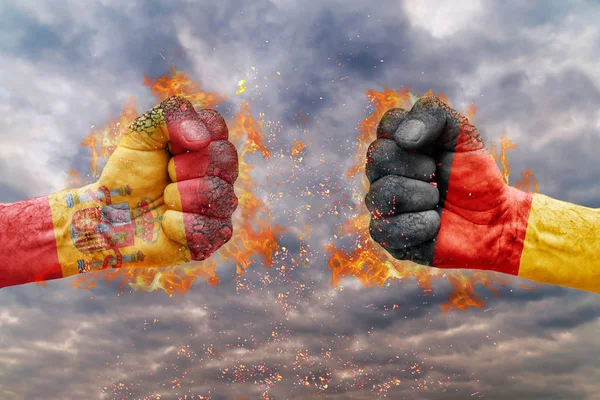 Два кулак з прапор Іспанії та Німеччини стикаються один на одного готові до боротьби — стокове фото