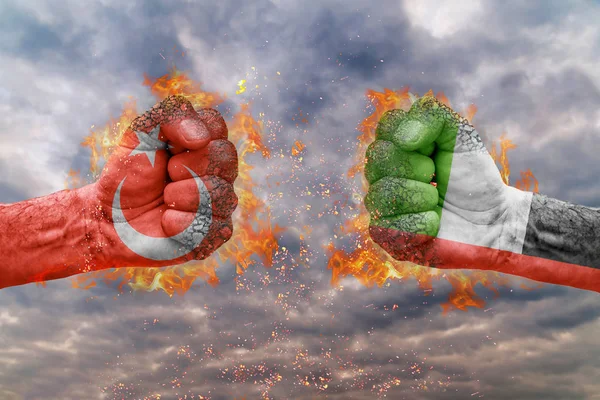 Два кулак з прапором Туреччини та Об'єднаних Арабських Еміратів стикаються один на одного готові до боротьби — стокове фото