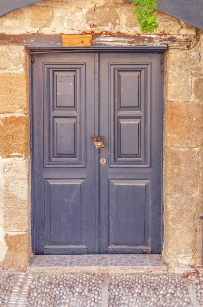 Porta de madeira escura fechada moderna na parede da casa texturizada de cimento amarelo — Fotografia de Stock