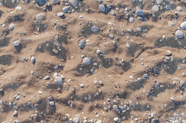 Natürliche Sand- und Kiessteinhintergrund an einem sonnigen Sommertag — Stockfoto