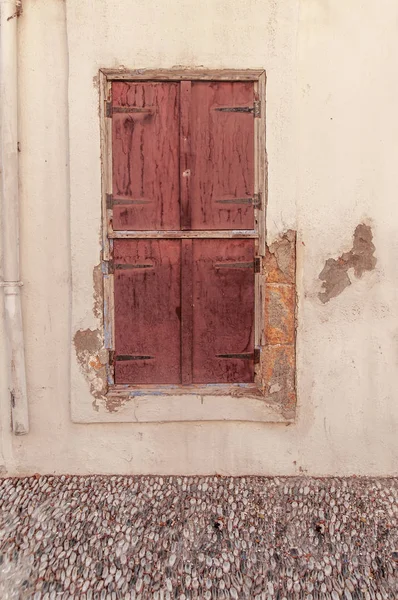 Régi rozsdás lezárt sötét vörös fából készült ajtó a sárga cement texturált ház falán — Stock Fotó