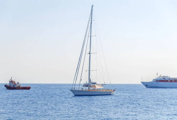 Un barco de lujo atracado en el mar y tres barcos que pasan con el cielo azul limpio —  Fotos de Stock
