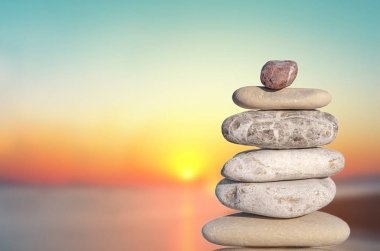 Birkaç gün batımından sembolü gibi karmaşık üzerinde zen için izole taş çakıl ve kavram rahatla