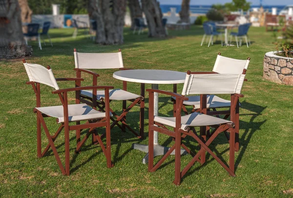 Table et quatre chaises dans le jardin avec gazon vert le jour de l'été — Photo