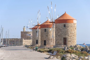 Üç kırmızı çatı eski fırıldak kenarı ile mavi bulutlu gökyüzü ve deniz feneri içinde belgili tanımlık geçmiş
