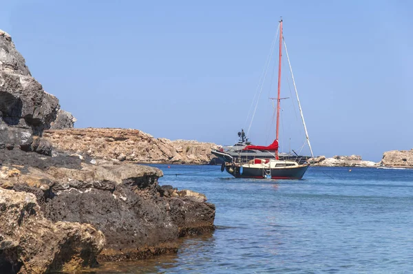 Dos barcos en el mar azul atracados y piedra de acantilado en el lado izquierdo —  Fotos de Stock