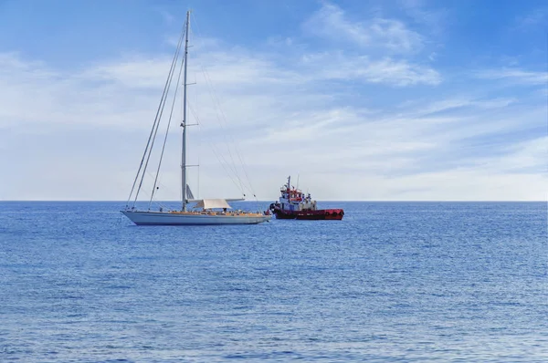 Dos barco atracado en el horizonte de mar azul tranquilo con nublado —  Fotos de Stock