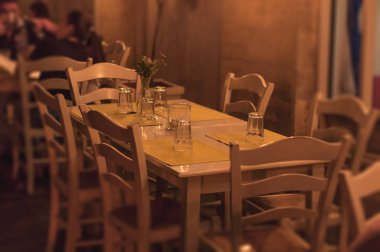 Terasta mum dışında altı için sarı bez ile beyaz restoran masası