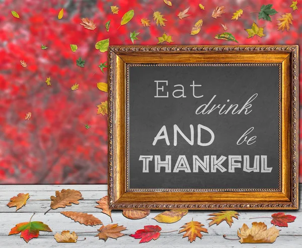 Eat drink and be thankful written inside picture frame with red background