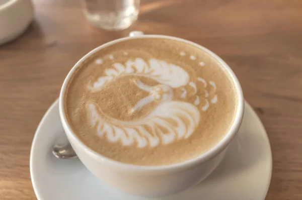 Latte art filiżanka do espresso z kształtu Sowa na piance na drewnianym stole — Zdjęcie stockowe