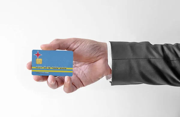 Bank karta kredytowa z flagą Aruba gospodarstwa człowiek w eleganckim garniturze — Zdjęcie stockowe