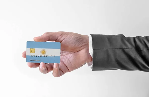 Bank karta kredytowa z flagą Argentyny gospodarstwa człowiek w eleganckim garniturze — Zdjęcie stockowe