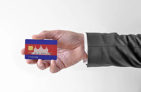 Bank credit plastic card with flag of Cambodia holding man in elegant suit — Stock Photo, Image