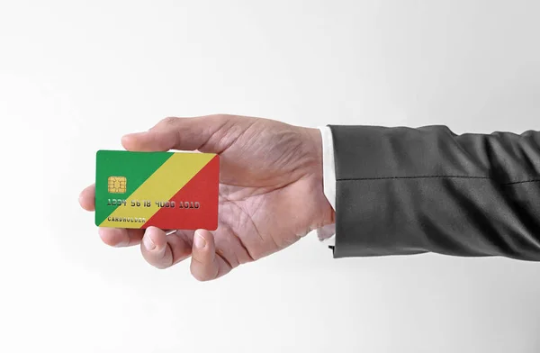Bankovní kreditní plastová karta s vlajkou Konžské republiky držící muže v elegantním obleku — Stock fotografie