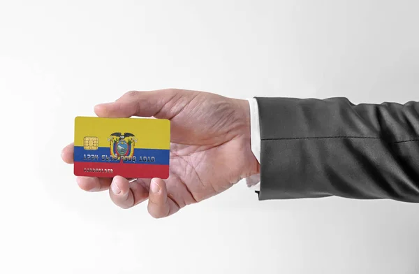 Banco cartão de crédito plástico com bandeira do Equador segurando homem em terno elegante — Fotografia de Stock