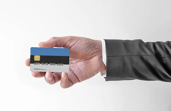 銀行クレジットプラスチックカードエストニアの国旗保持男でエレガントなスーツ — ストック写真