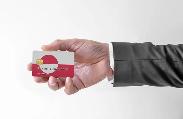 Carte de crédit bancaire en plastique avec drapeau du Groenland tenant l'homme en costume élégant — Photo