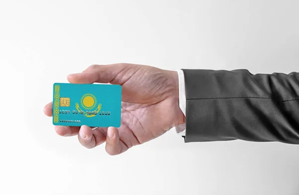 Bank karta kredytowa z banderą Kazachstanu gospodarstwa człowiek w eleganckim garniturze — Zdjęcie stockowe