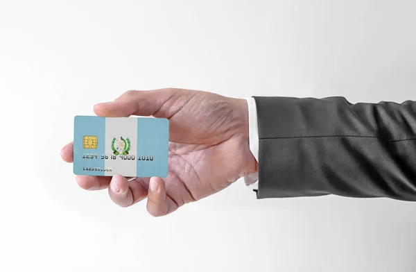 Cartão de crédito bancário de plástico com bandeira da Guatemala segurando homem em terno elegante — Fotografia de Stock