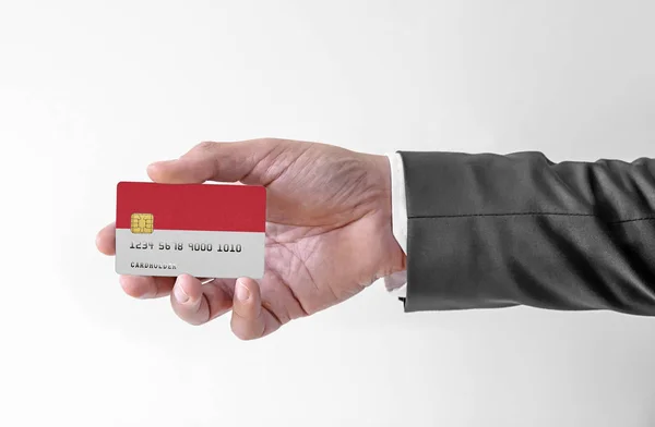 Τράπεζα πιστωτική πλαστική κάρτα με σημαία του Μονακό κρατώντας άνθρωπος σε κομψό κοστούμι — Φωτογραφία Αρχείου