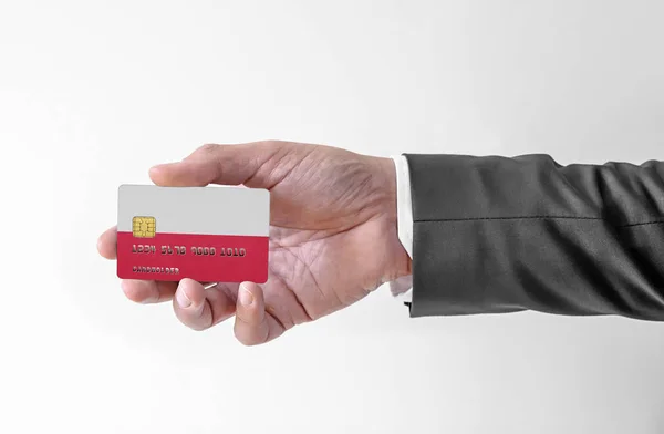 Bankovní kreditní plastová karta s vlajkou Polska držící muže v elegantním obleku — Stock fotografie