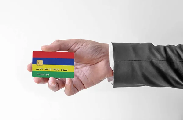 Karta kredytowa banku z flagą Mauritiusa posiadacza człowieka w eleganckim garniturze — Zdjęcie stockowe