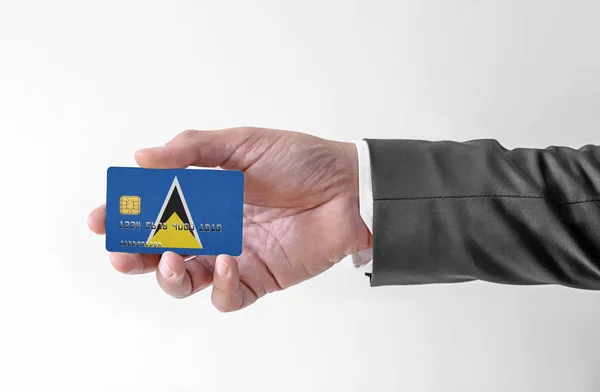 Bankovní kreditní plastová karta s vlajkou Saint Lucia držení muž v elegantním obleku — Stock fotografie