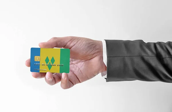 Bankovní kreditní plastová karta s vlajkou Svatého Vincence a Grenadin drží člověka v elegantním obleku — Stock fotografie