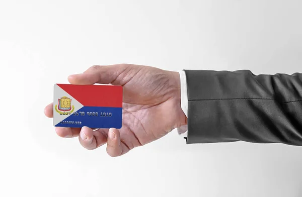 Karta kredytowa banku z flagą Sint Maarten holding man w eleganckim garniturze — Zdjęcie stockowe