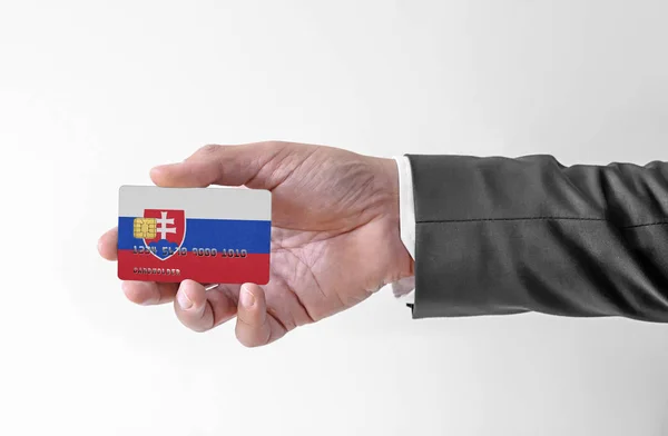 Bank karta kredytowa z banderą Słowacji holding man w eleganckim garniturze — Zdjęcie stockowe
