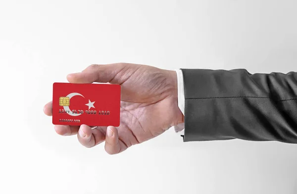 Bank credit plastic card with flag of Turkey holding man in elegant suit — Stok fotoğraf