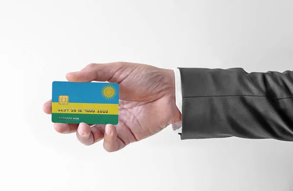 Bankovní kreditní plastová karta s vlajkou Rwandy držící muže v elegantním obleku — Stock fotografie