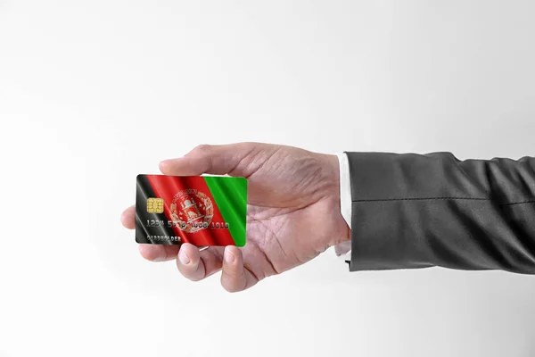 Muž v elegantním obleku s bankovní kreditní kartou s vlajkou Afghánistánu — Stock fotografie